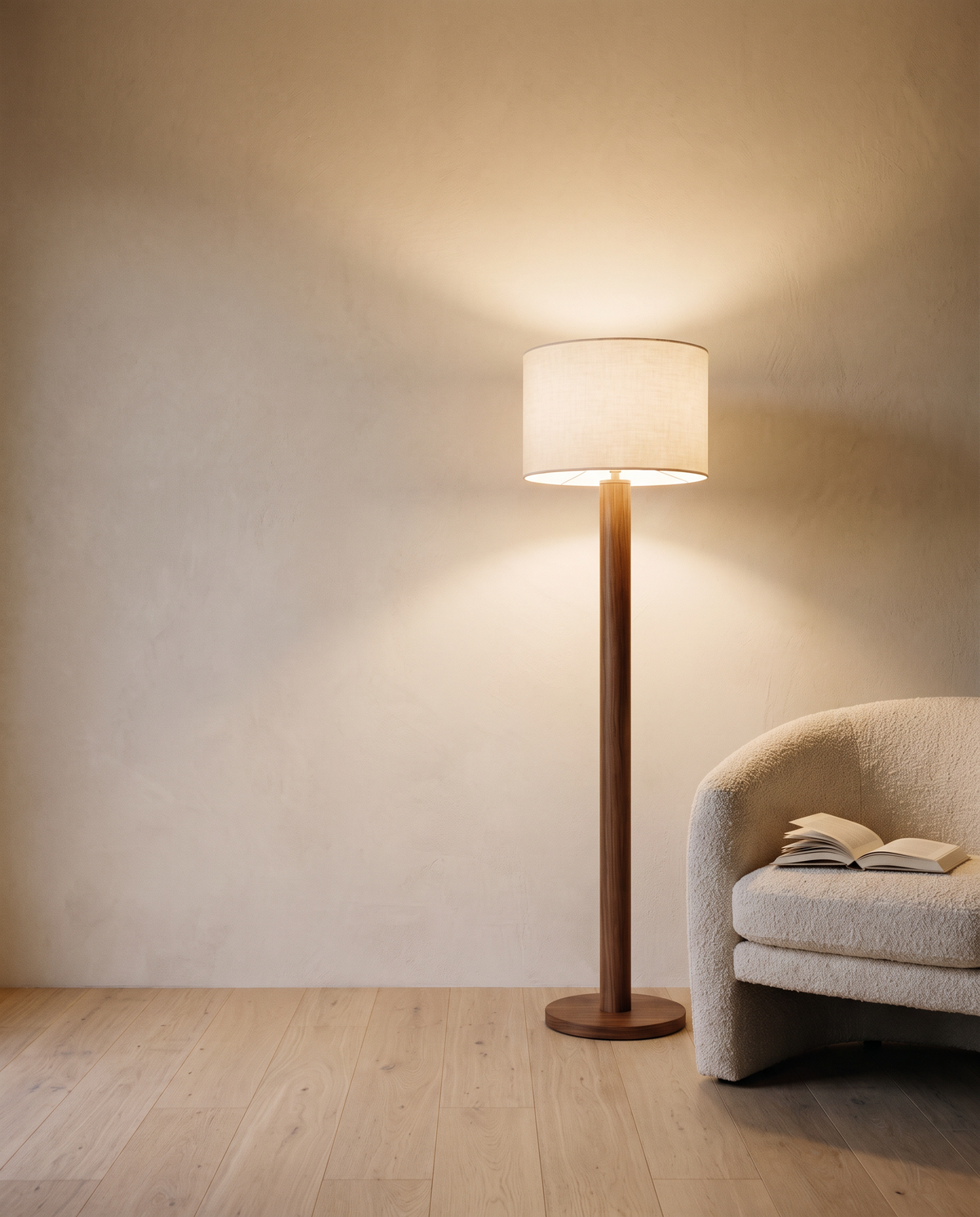 Walnut-tone floor lamp beside a bouclé reading chair in the evening