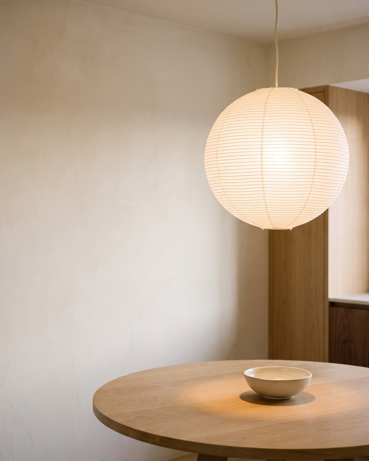 Paper lantern pendant over an oak dining table